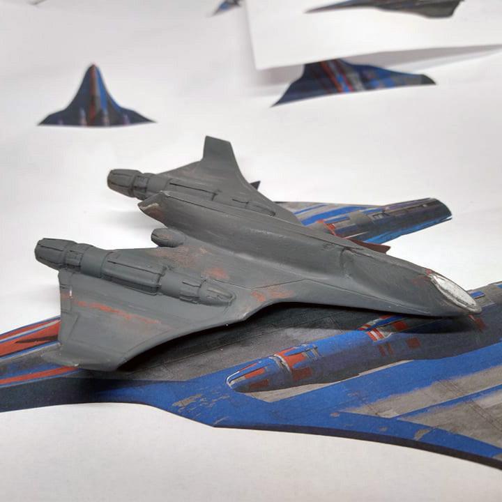 Resin model partially painted and shown on blueprints